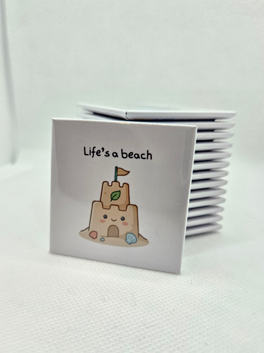 Magnet with an illustration of a cartoon sandcastle and words Life's a beach