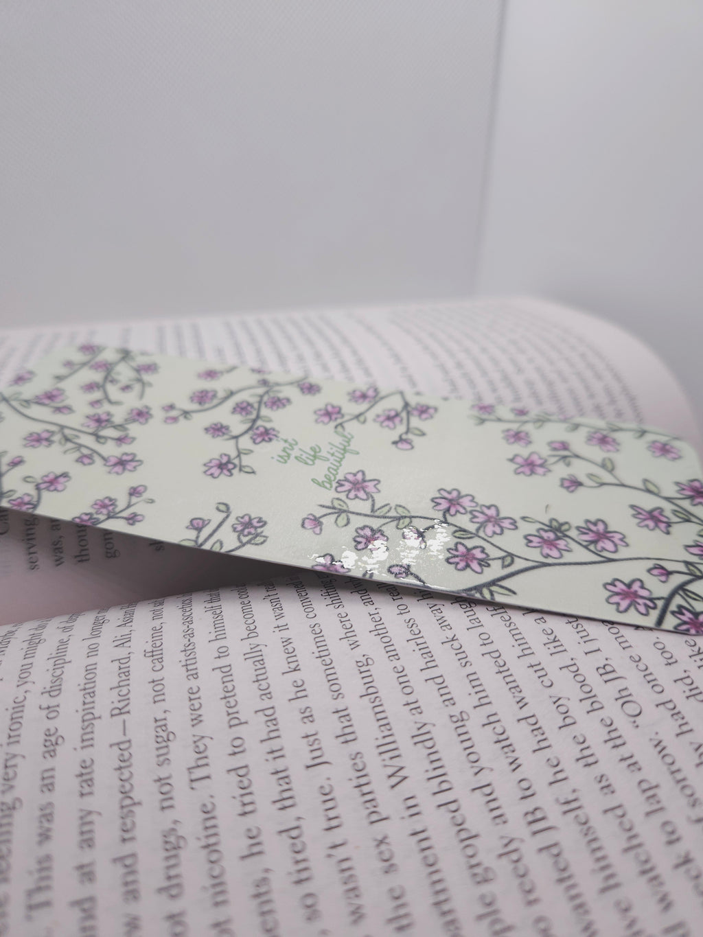 Floral bookmark on an open book with text visible