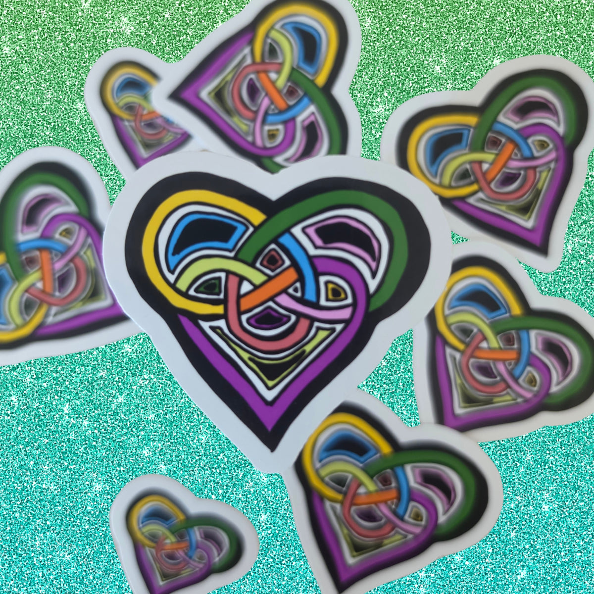 A set of die-cut heart-shaped stickers featuring a colorful, layered Celtic knot design on a sparkling turquoise background.