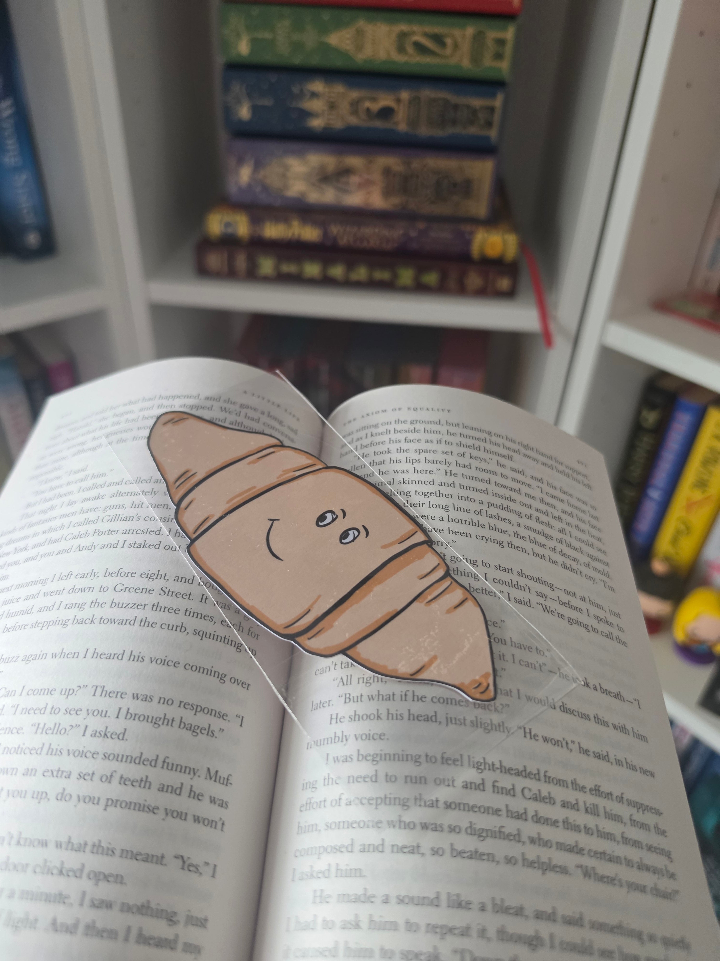 cute little croissant bookmark displayed on an open book