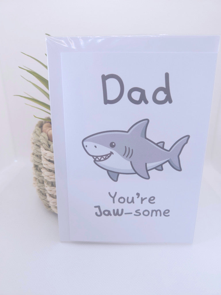Card with a shark illustration and text 'Dad, You're Jaw-some' on a light purple background.