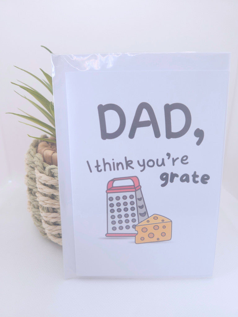 Card with a grater and cheese illustration and text 'Dad, I think you're grate' on a light background.