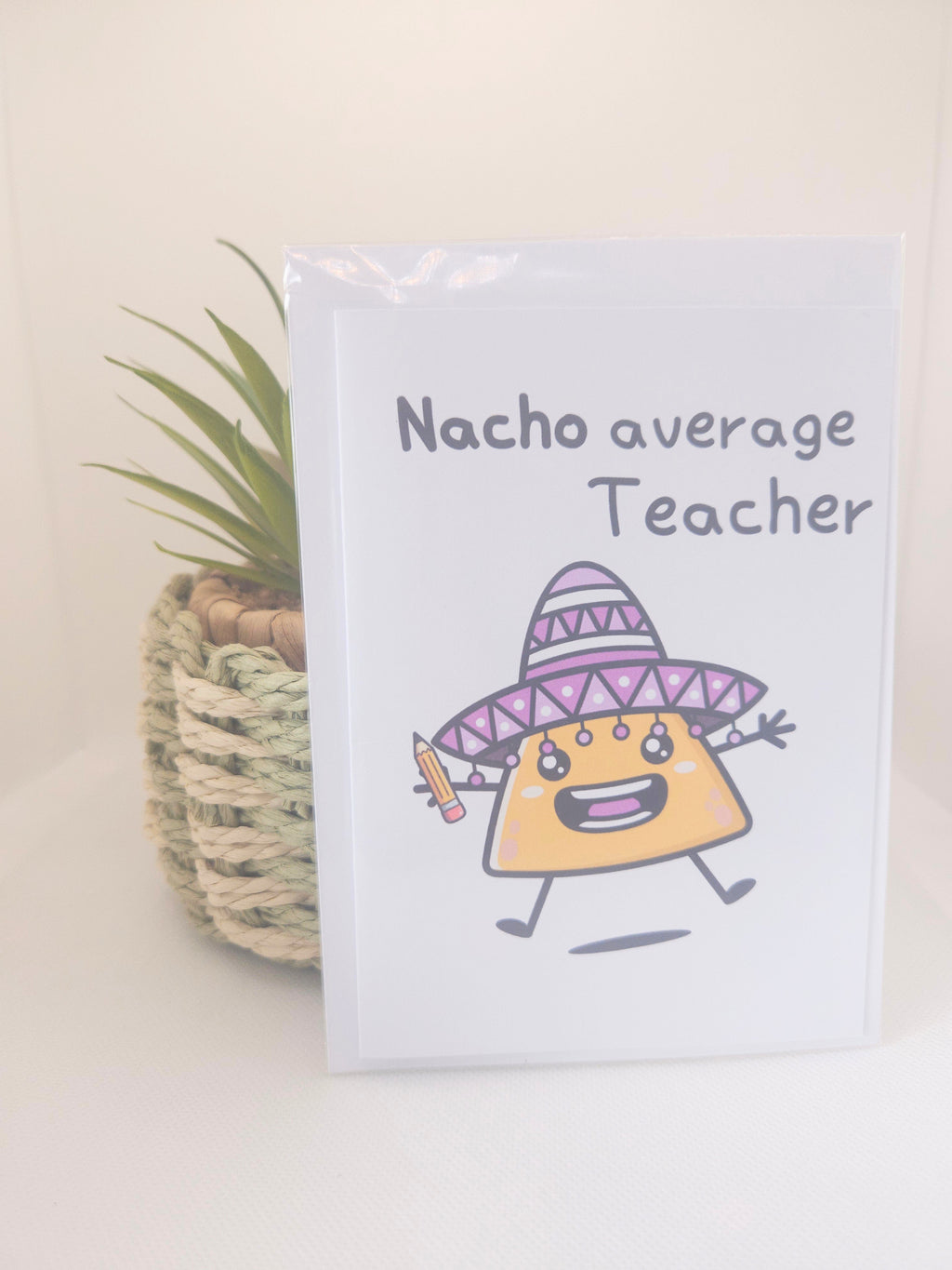 Notebook with cartoon taco wearing a witch hat and the text 'Nacho average Teacher' on a light background.