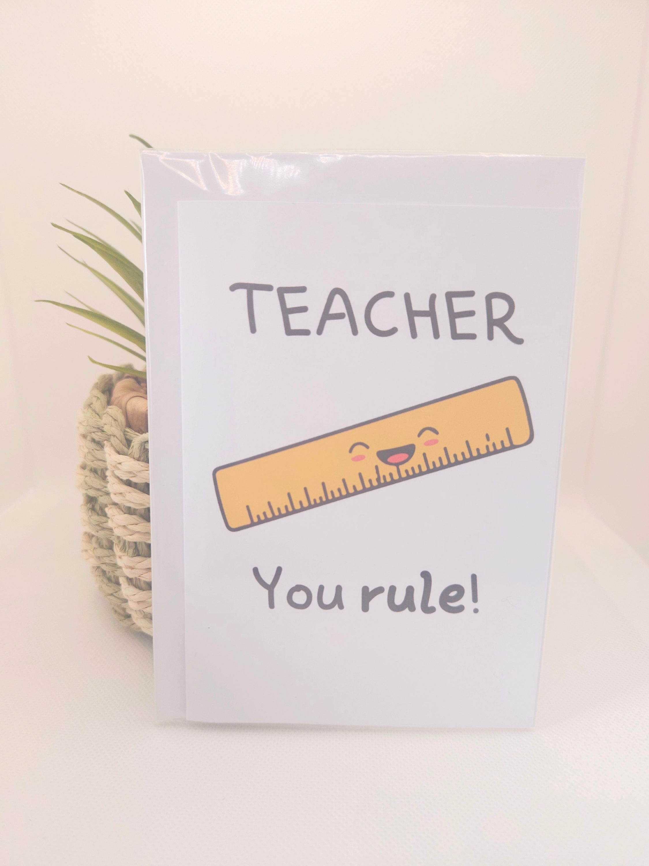 Card with a cartoon ruler and 'Teacher You Rule!' text on a light background