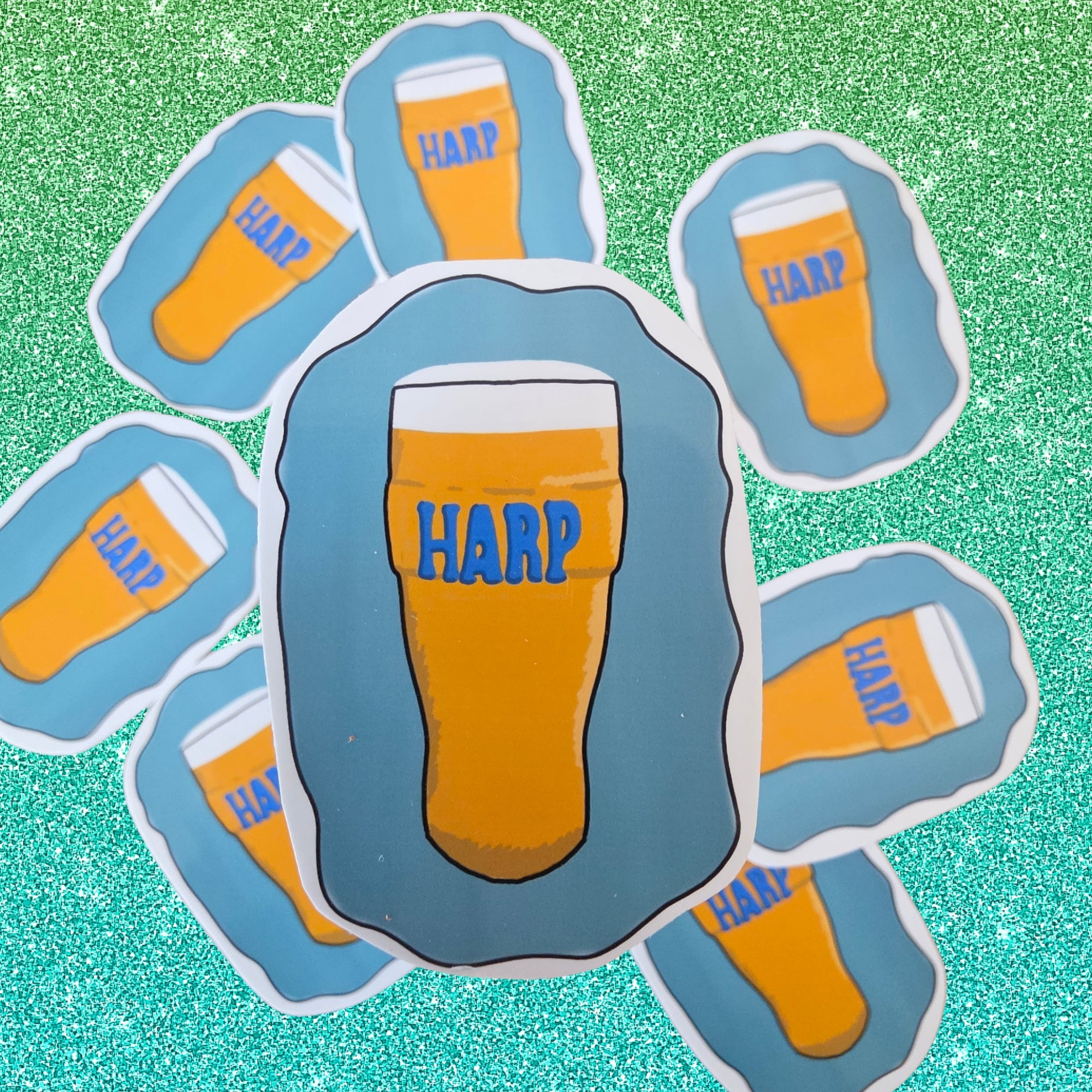A set of die-cut stickers featuring cartoon pint glasses filled with beer and the word 'HARP' in blue, arranged on a sparkling green background.