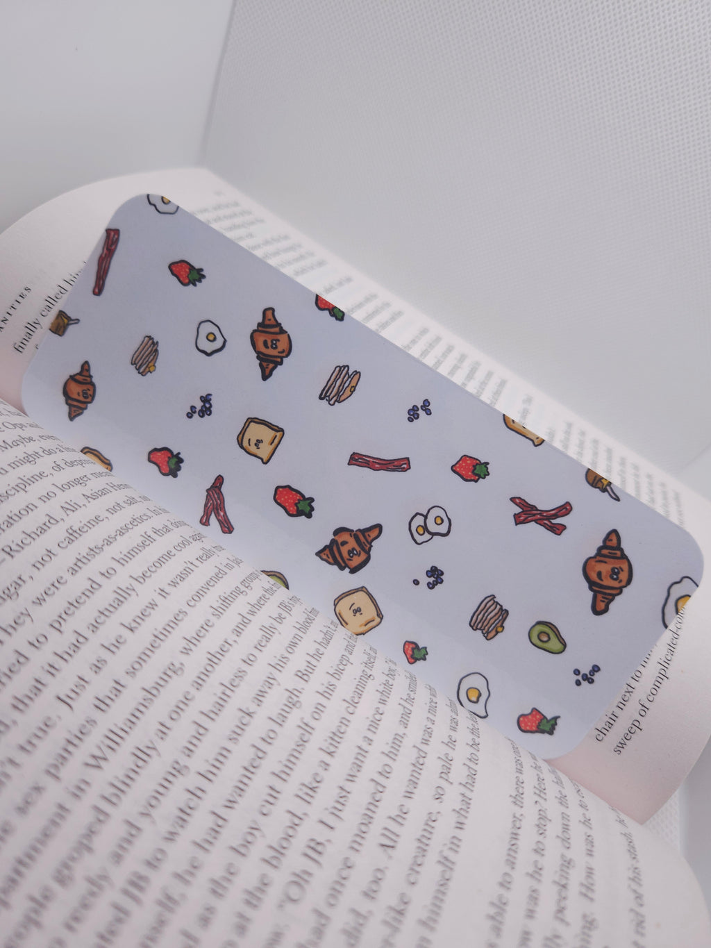 bookmark with hand drawn food-themed design, displayed on a book