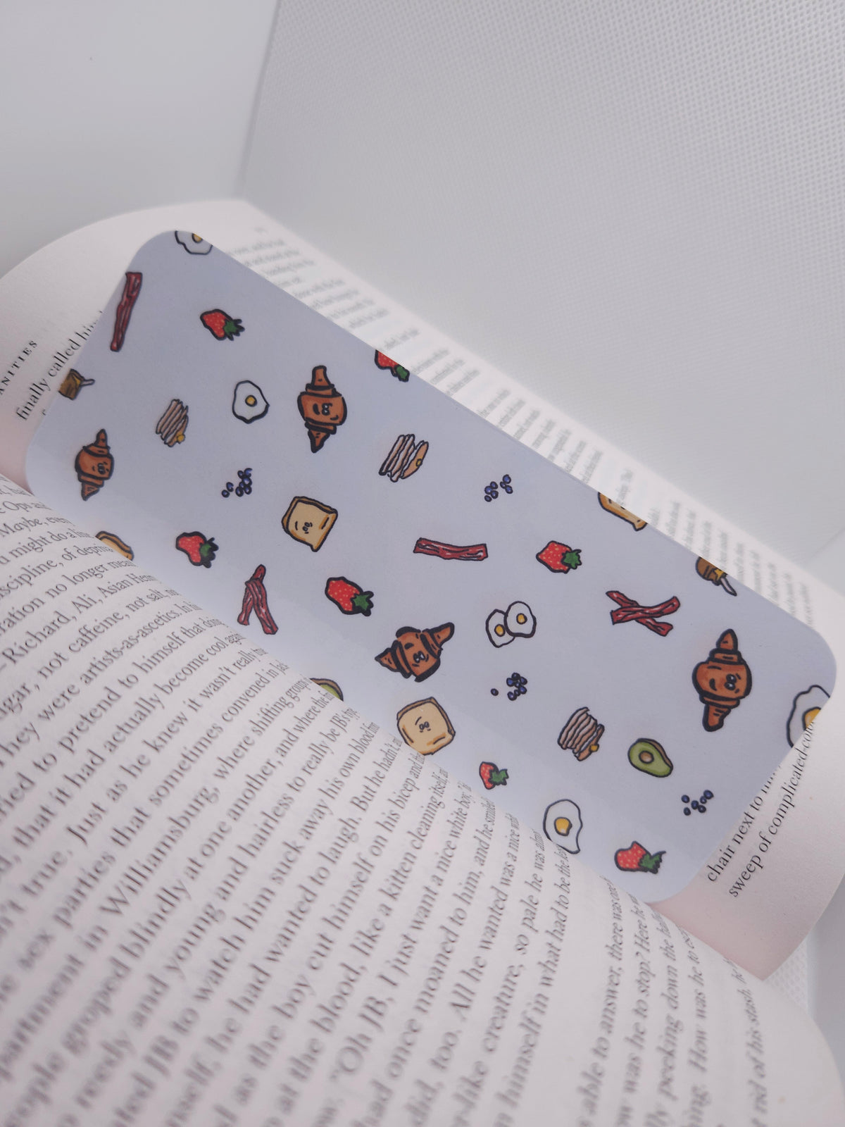 bookmark with hand drawn food-themed design, displayed on a book