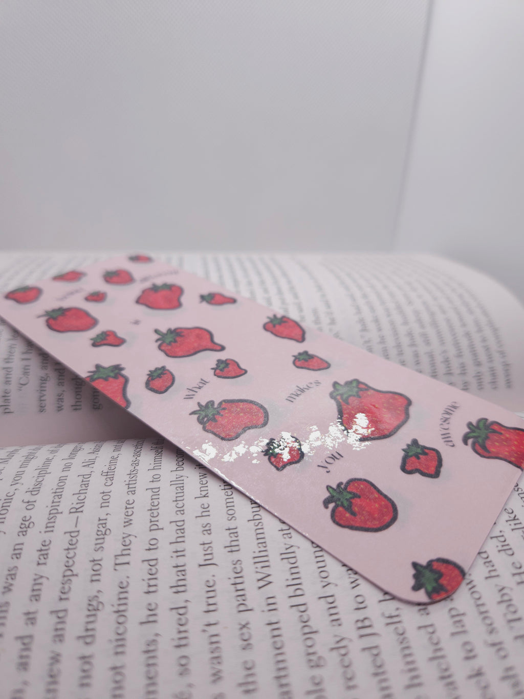 Pink bookmark with strawberry pattern on a book