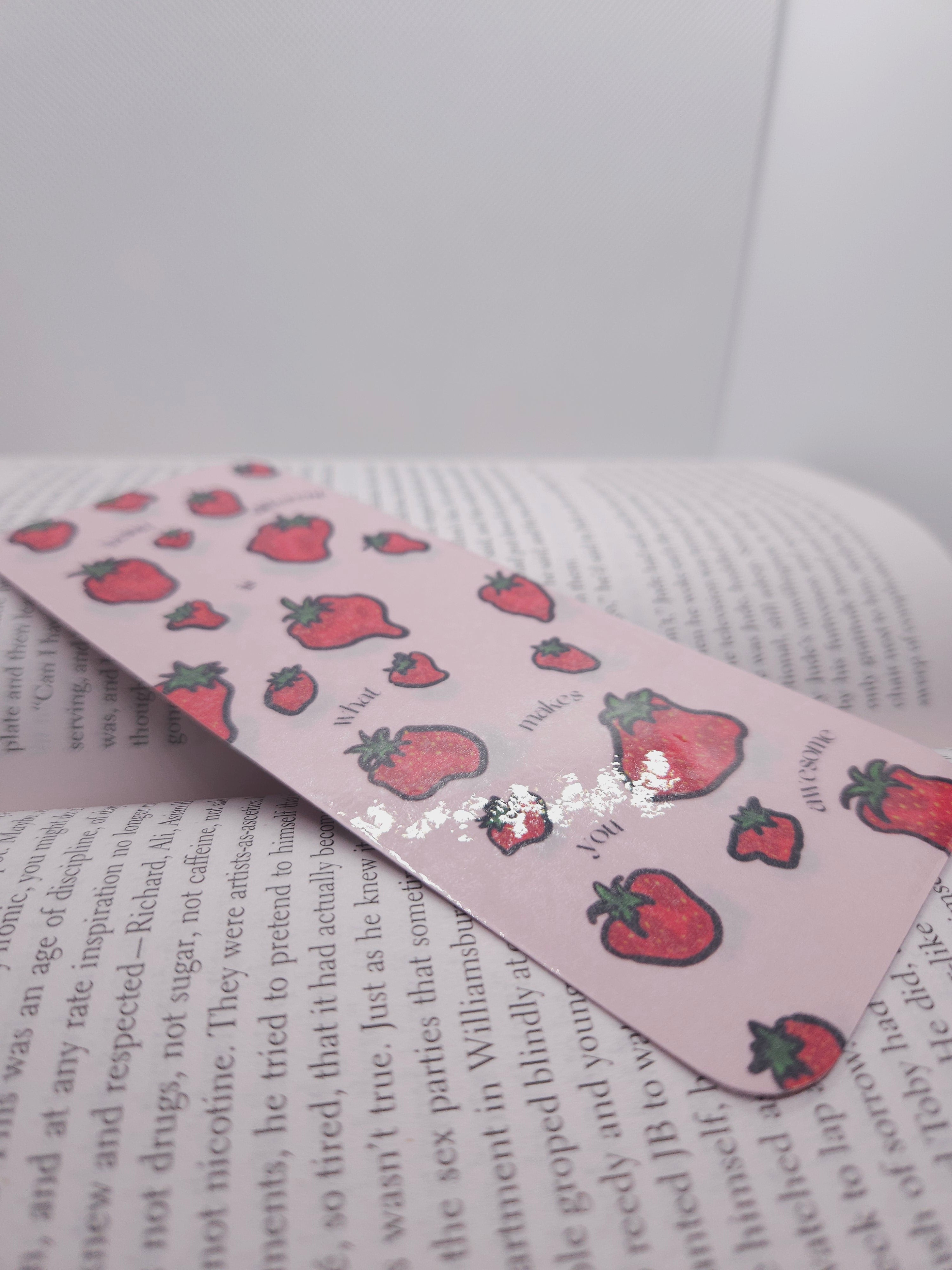 Pink bookmark with strawberry pattern on a book
