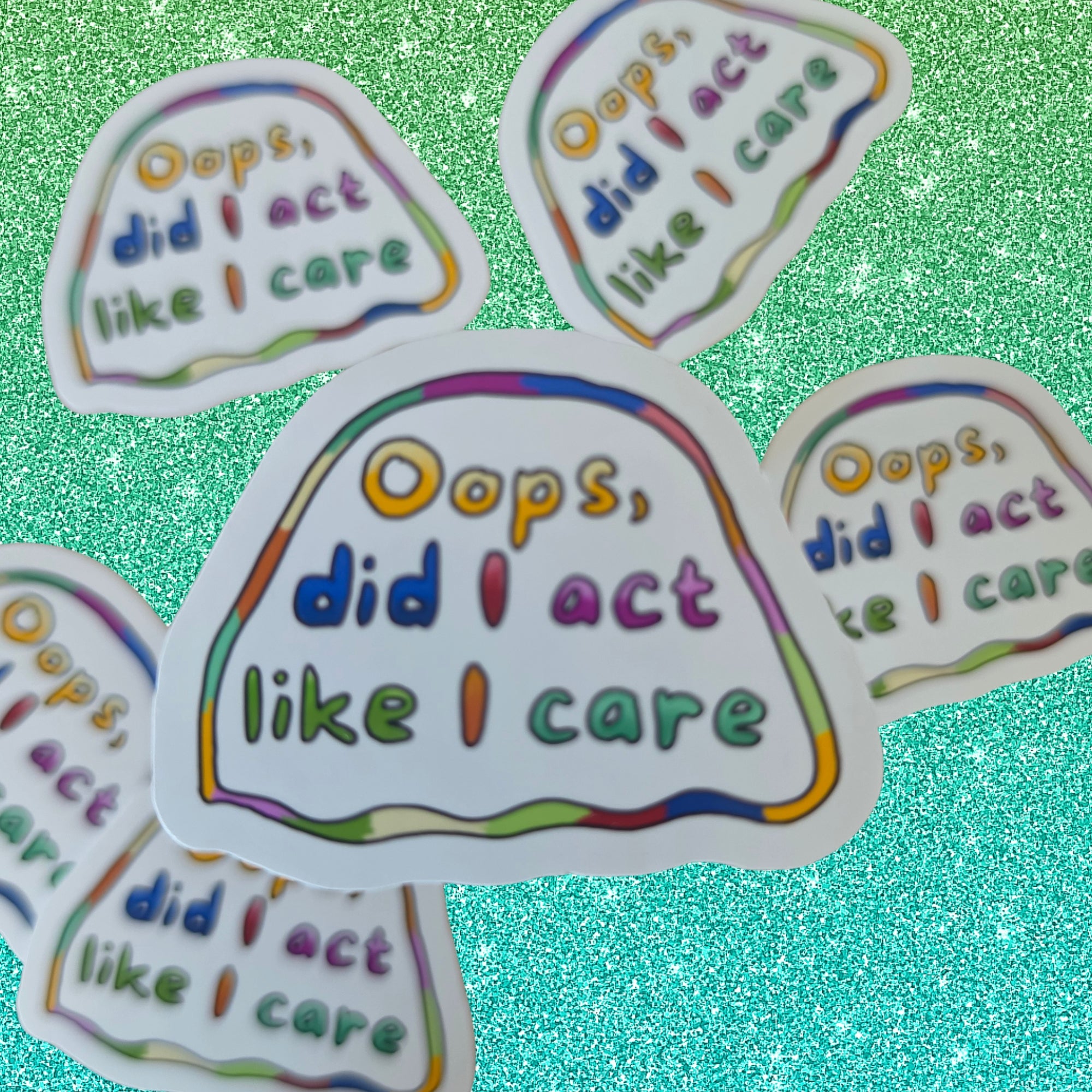 Five die-cut stickers with the phrase 'Oops, did I act like I care' in multicolored lettering on a white background, arranged on a glittery turquoise surface.
