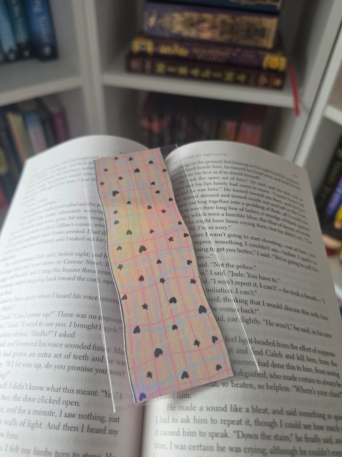 pink skinny holographic bookmark displayed in an open book