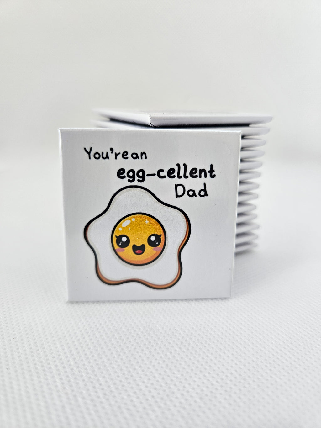 magnet with an egg illustration and text on a white background