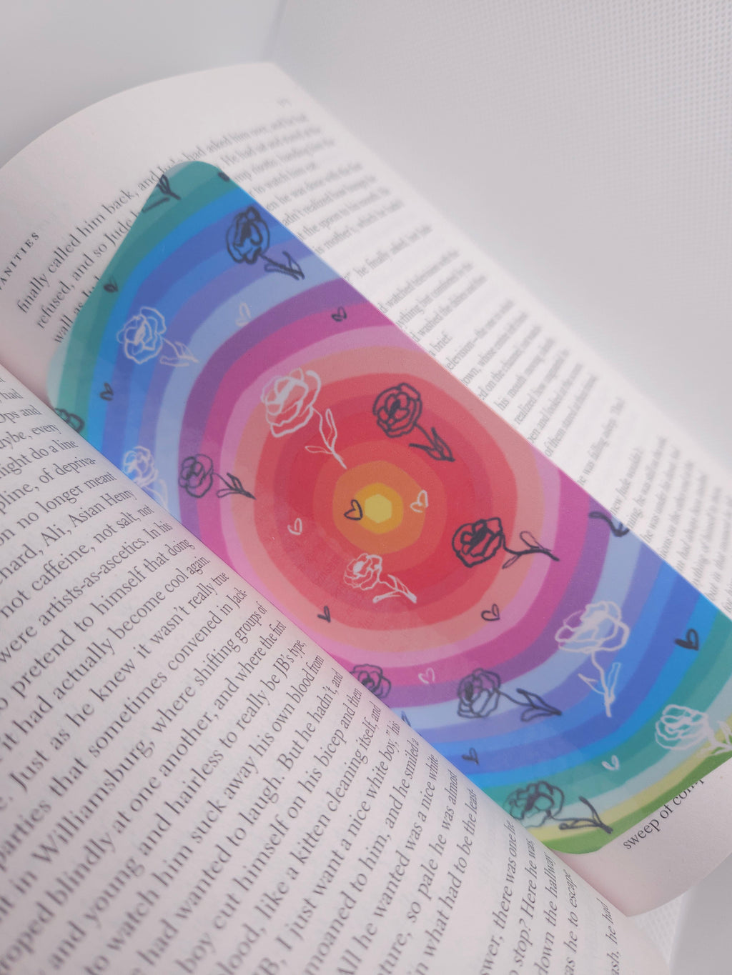 Colorful bookmark with a circular design featuring hand drawn peonies on an open book.