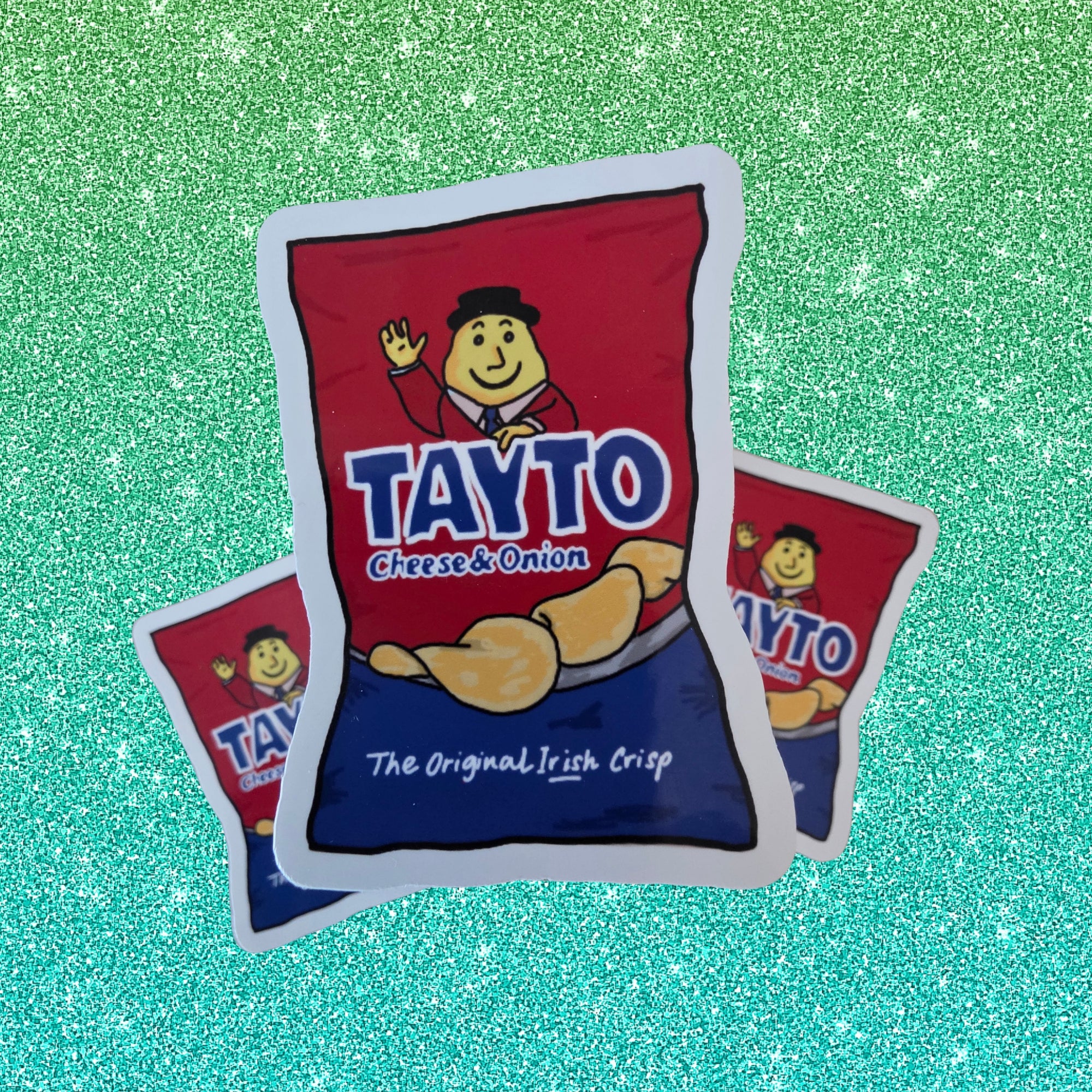 die cut stickers styled like bags of Tayto Cheese & Onion crisps, arranged on a sparkling green background.
