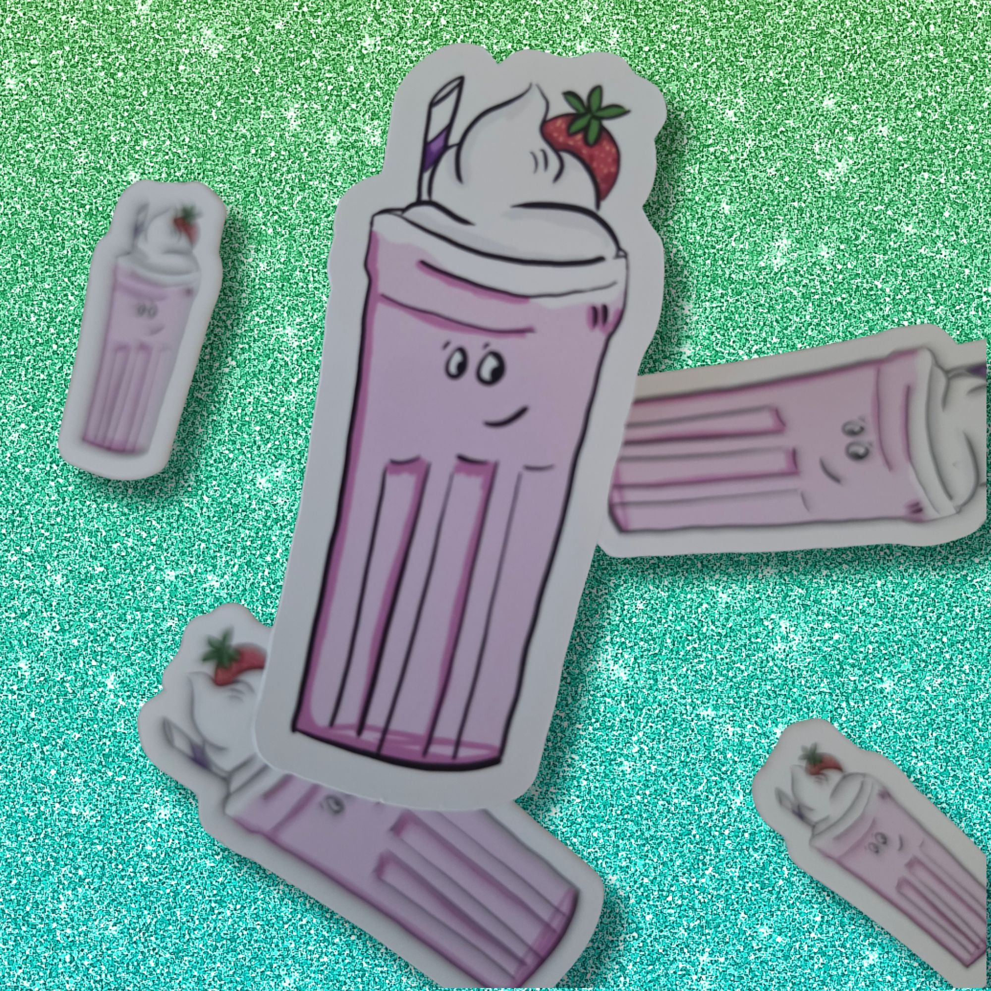 A set of cute, die-cut stickers featuring an anthropomorphic pink milkshake character with a face, whipped cream, and a strawberry, displayed on a sparkling green background.