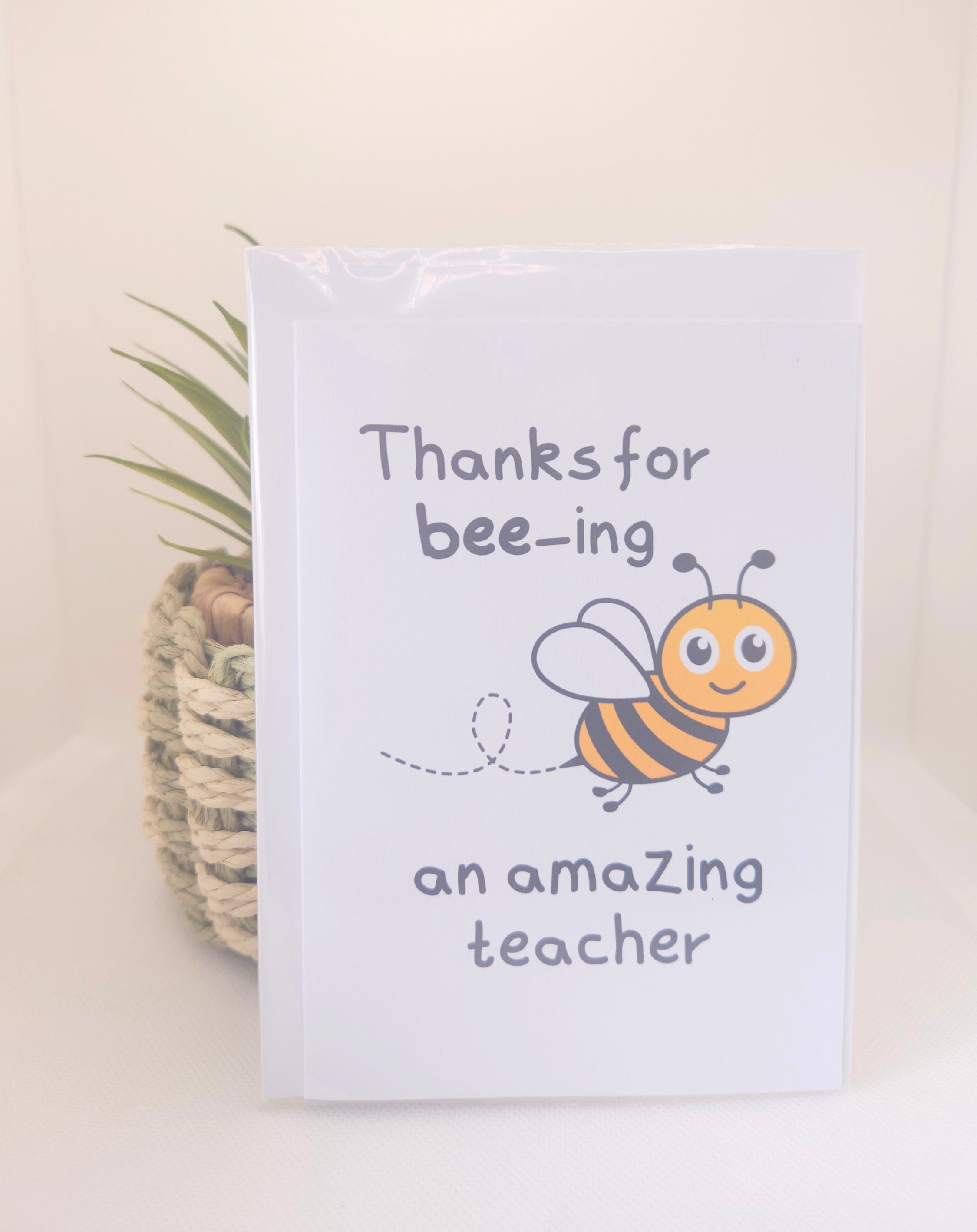 Card with a bee illustration and text 'Thanks for bee-ing an amazing teacher' on a light background.