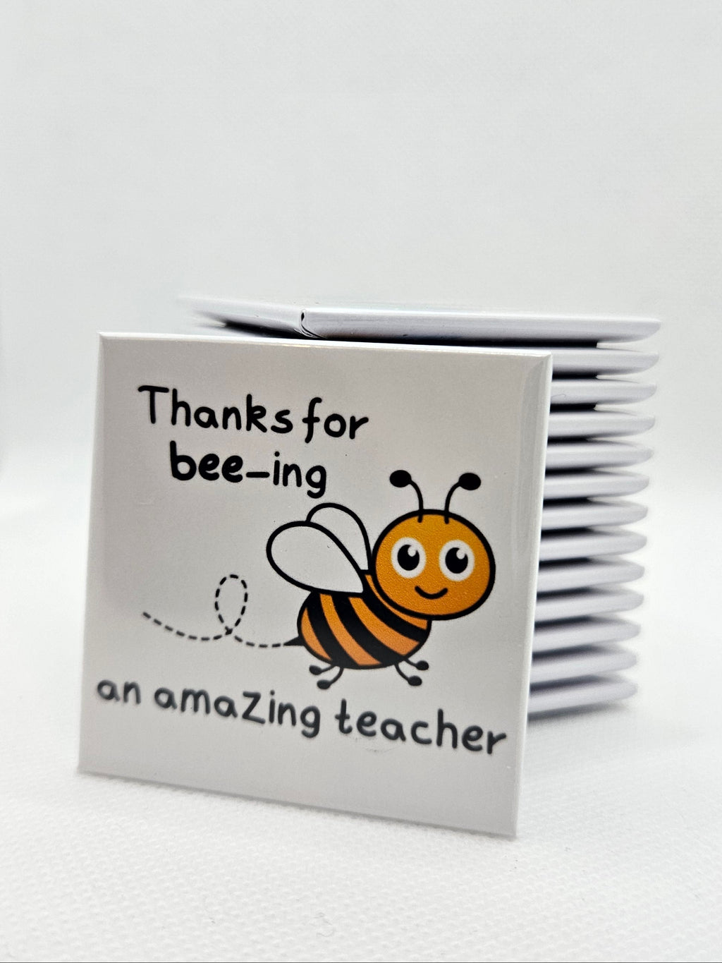 magnet with a bee illustration and text on a white background