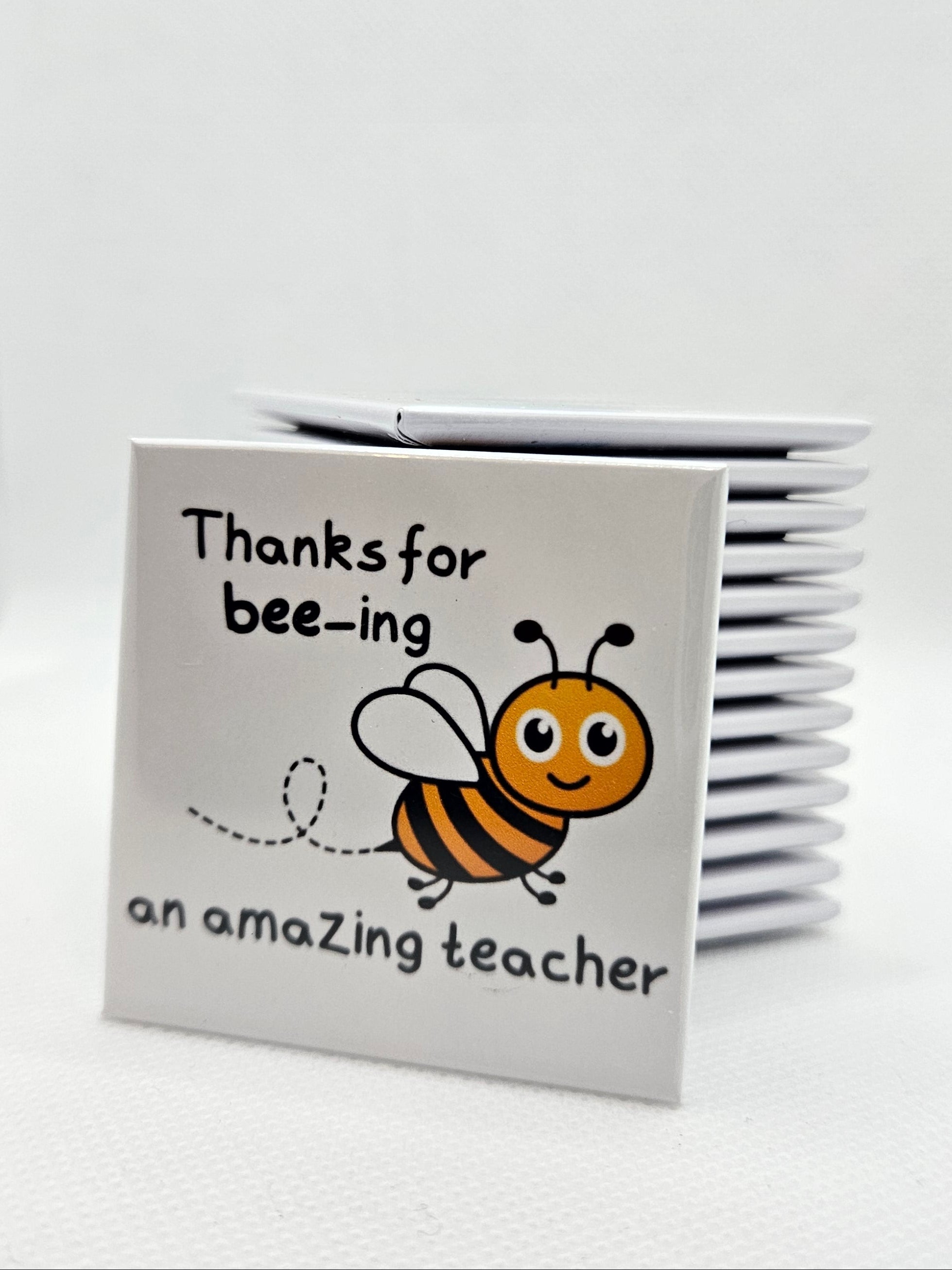 magnet with a bee illustration and text on a white background
