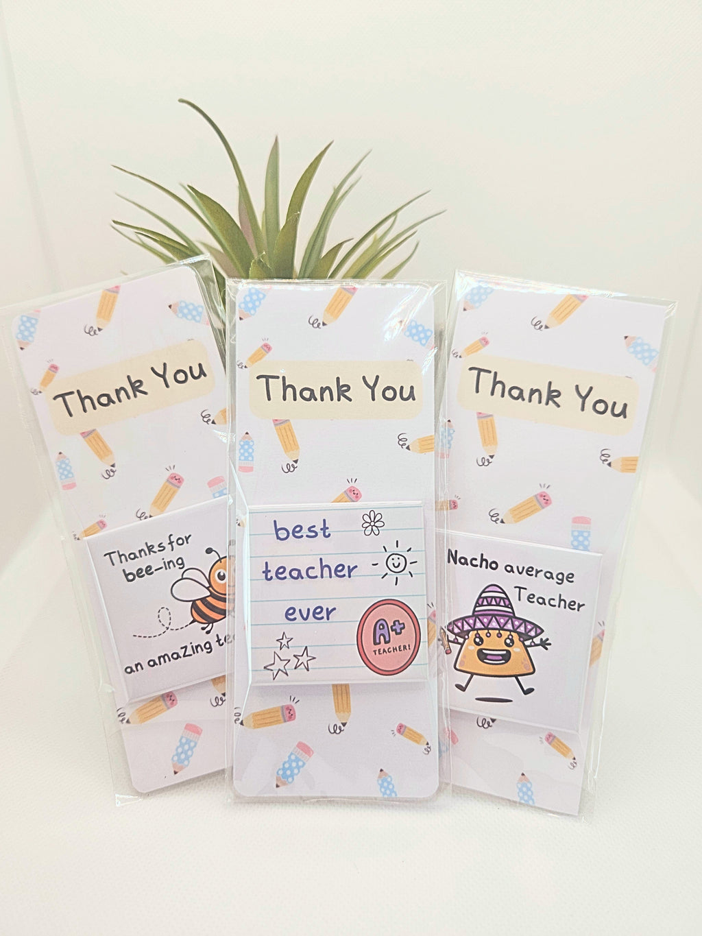 three thank you teacher bookmarks with teacher themed magnets attached