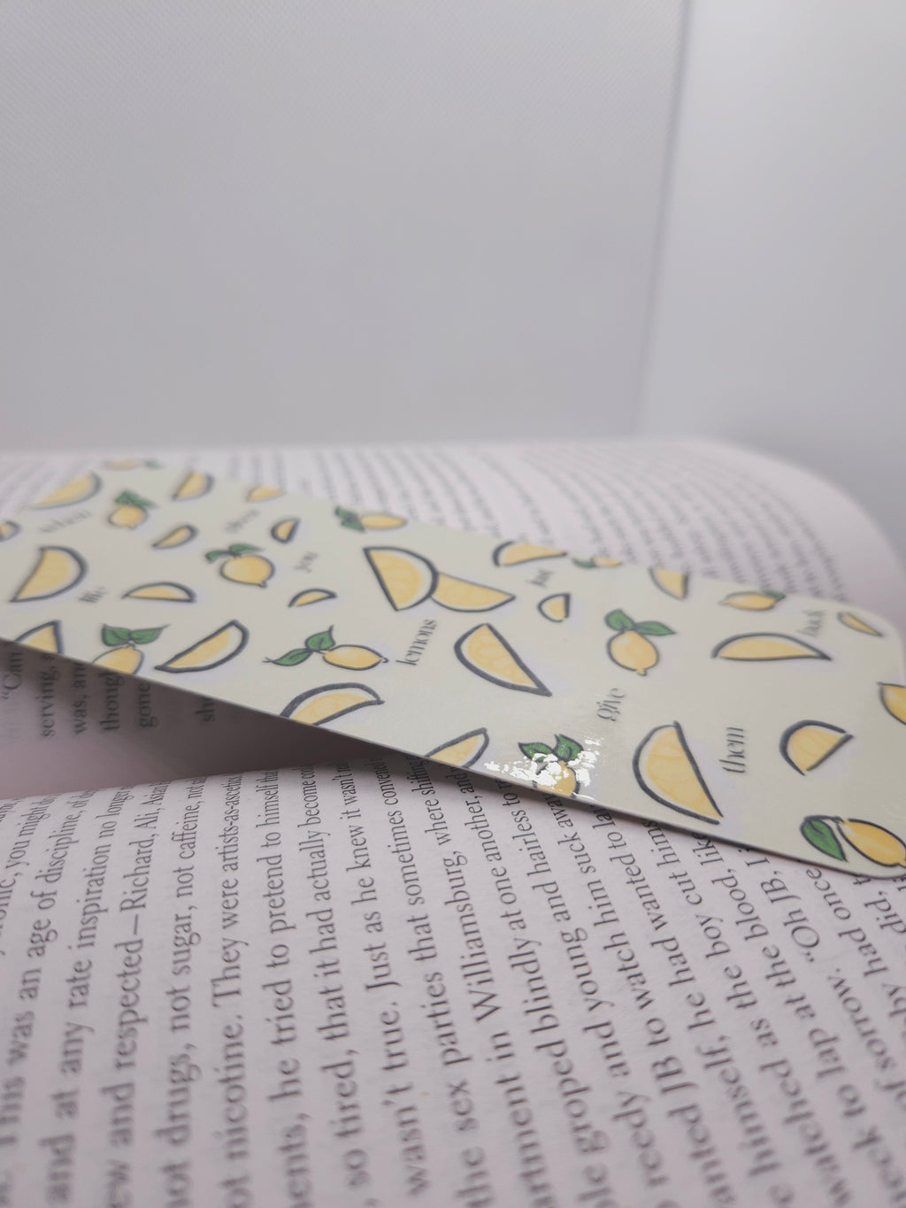 Book with a lemon-patterned bookmark on a white background