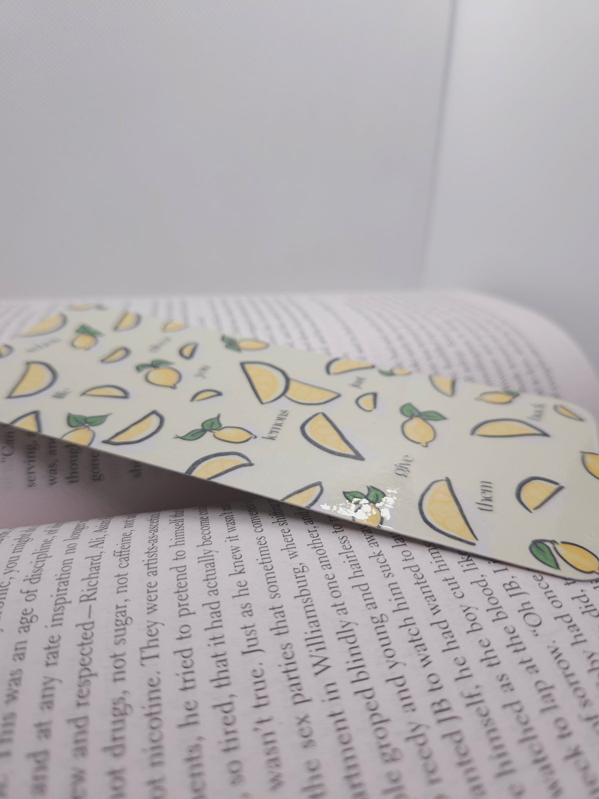 Book with a lemon-patterned bookmark on a white background
