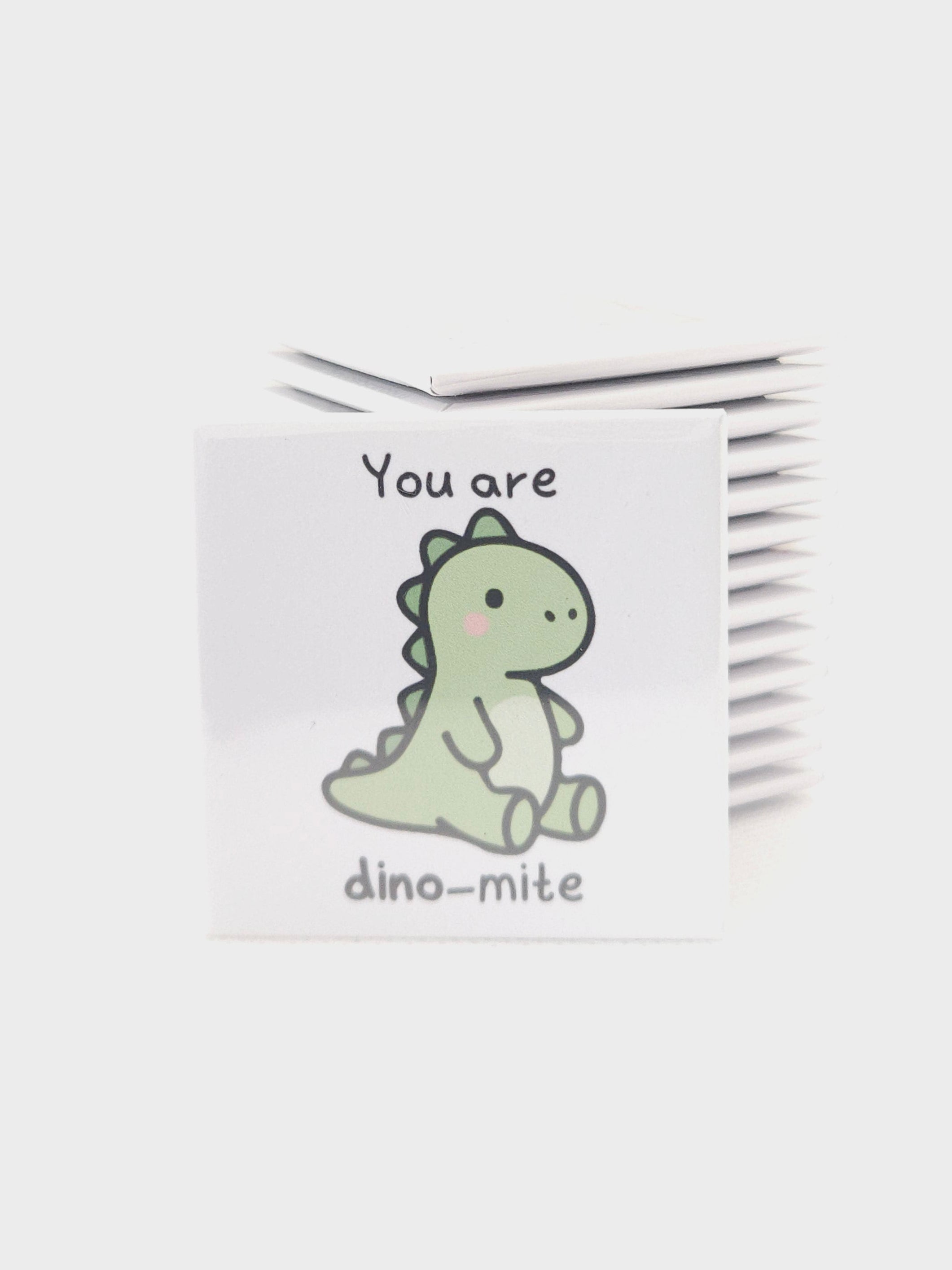 White magnet with a dinosaur design and text on a white background