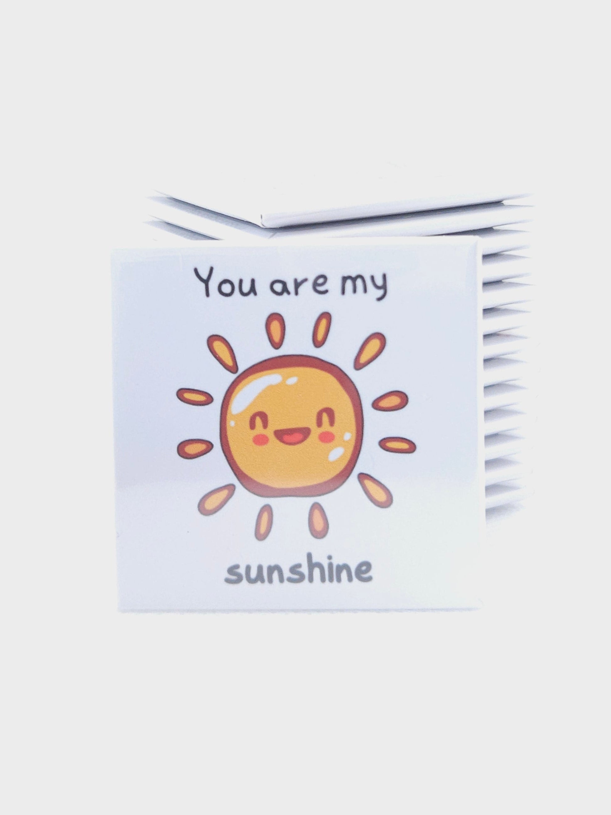 magnet  with a sun design and text on a white background