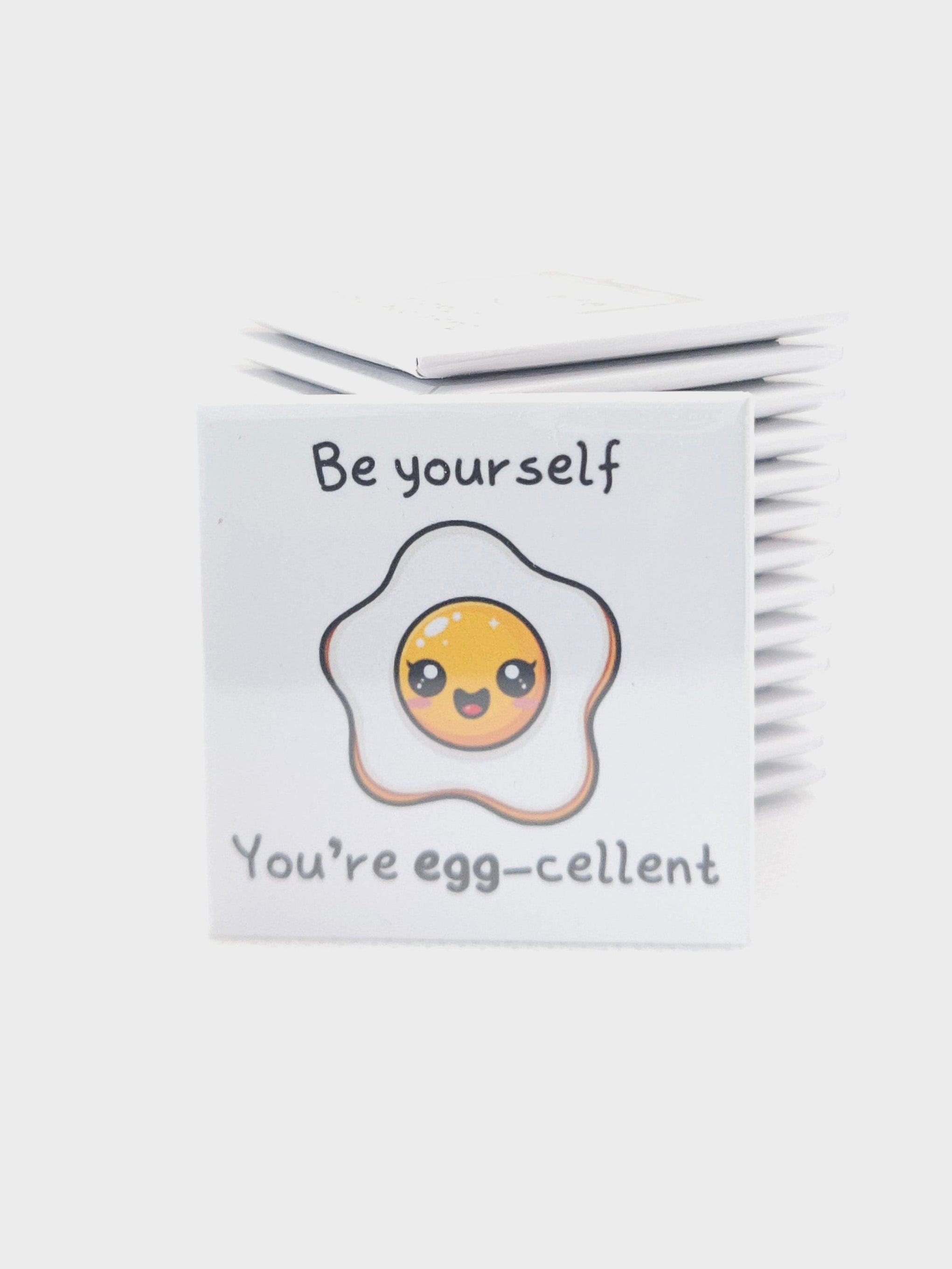 magnet with an egg illustration and text on a white background