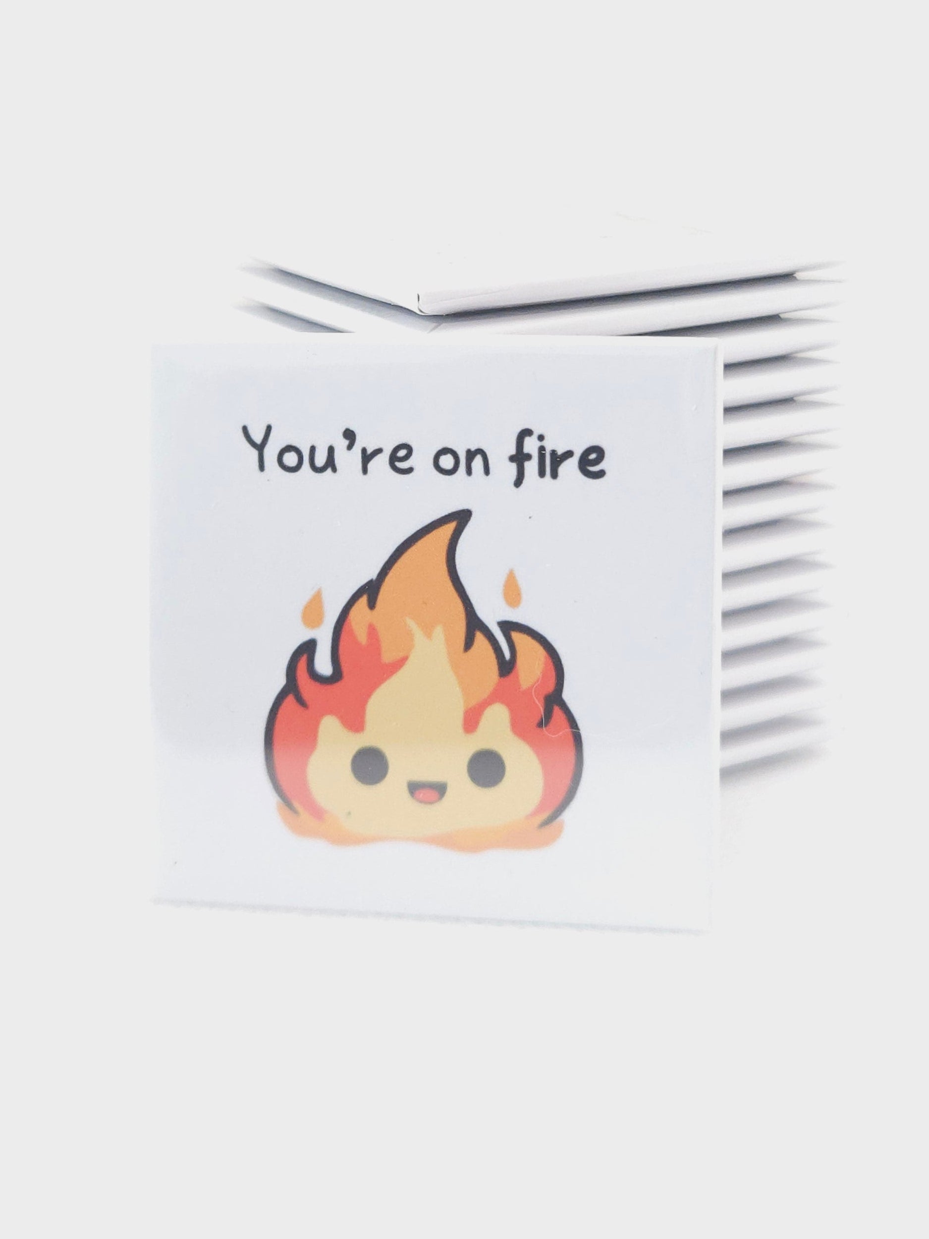 white magnet with cartoon flames, you're on fire